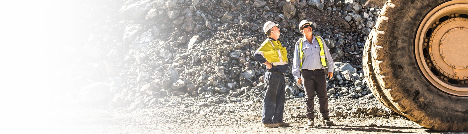 Two people looking up at a haul truck