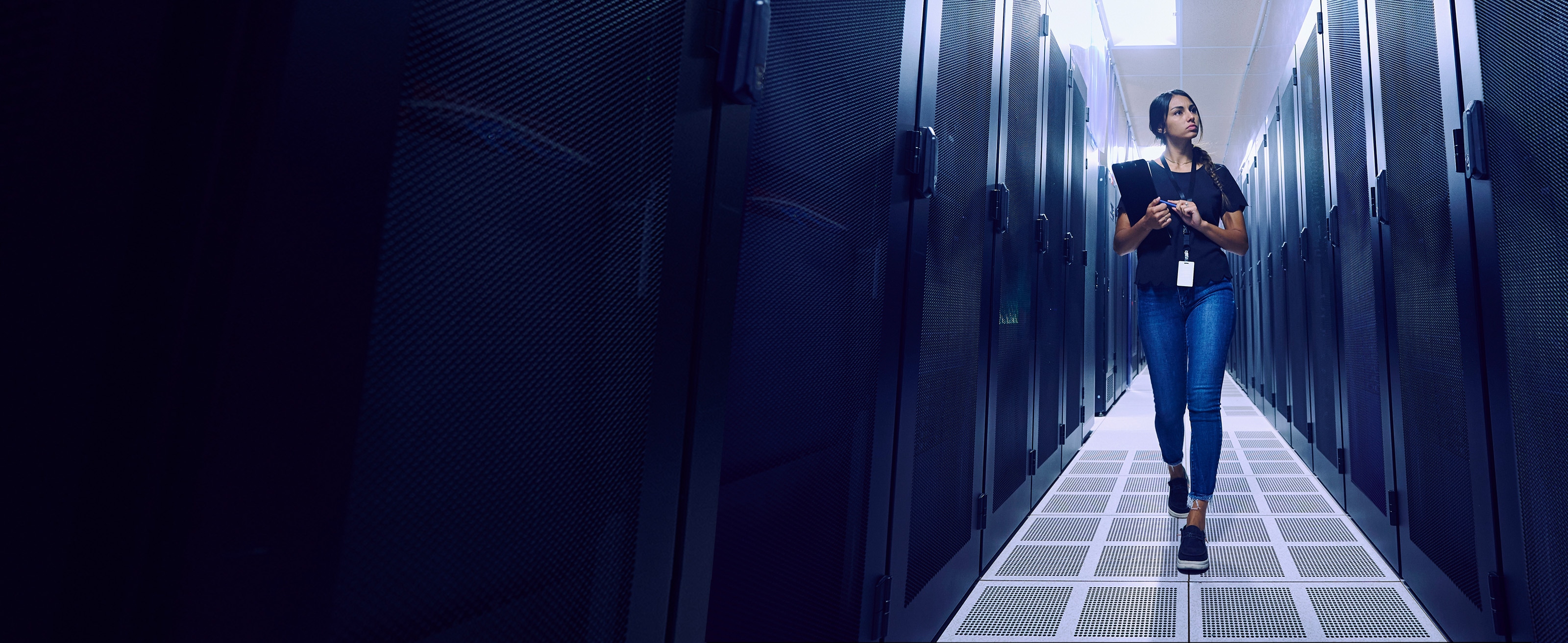 IT worker with clipboard walking through enterprise server room