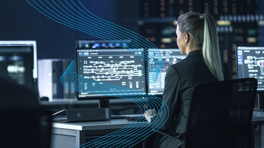 Employee working at a command center and looking at multiple screens