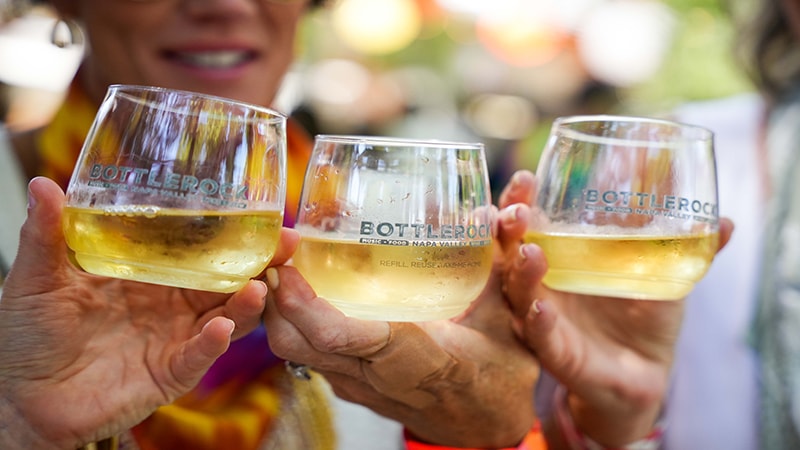 Three people holding up wine glasses at BottleRock