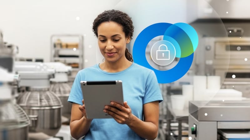 A person using a tablet in a commercial kitchen with a digital security padlock icon overlay.