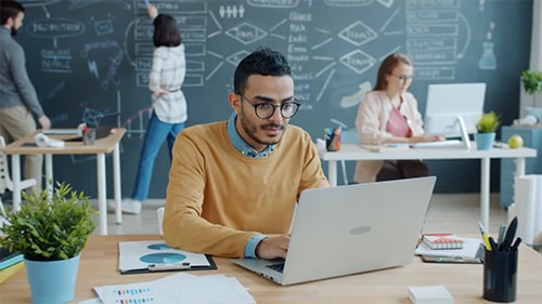 Person sitting at a laptop in an office setting